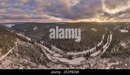 Germany, Thuringia, Gehren, forest, valley, brook, forest roads, snow, Rennsteig environment, back light, shortly before sunset, aerial view, panorama Stock Photo