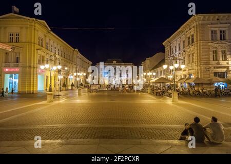 SZEGED, HUNGARY - JULY 20, 2017: Selective blur people standing on the deserted Klauzal ter square  near Kossuth Lajos Statue in the city center of Sz Stock Photo