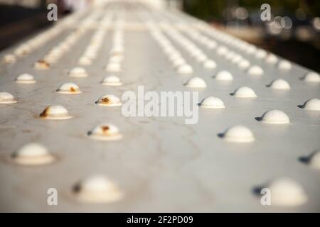 Selective blur on White Metal Rivets on an industrial metallic bridge, some old and rusted. They are a symbol of heavy industry, steelwork and the fir Stock Photo