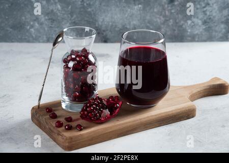 A pitcher full of pomegranate and a cup of juice Stock Photo