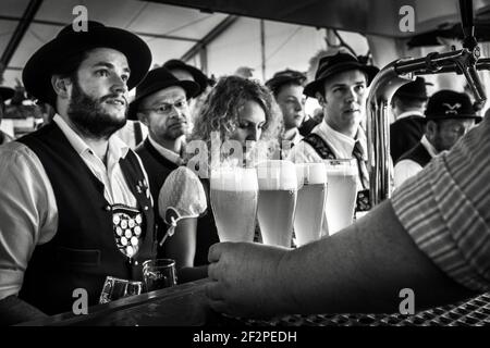 Germany, Bavaria, Antdorf, festival week of the traditional costume association. Visitors to the marquee are waiting for their beer. Stock Photo