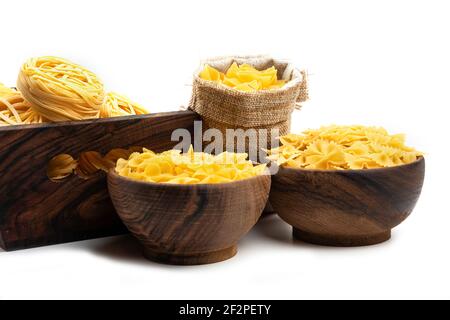 Various types of uncooked pasta in wooden bowls and sack bag Stock Photo