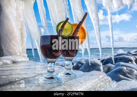 Hot mulled wine made from red wine with rum. Spiced with citrus fruits, cinnamon, cloves and star anise. The drinks are served on the icy Baltic Sea beach. Stock Photo