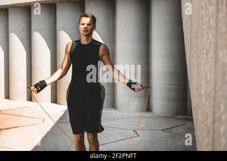 caucasian man fighter training hard in the outdoors.. Man using rope, making warm up. concept about sport and boxing Stock Photo