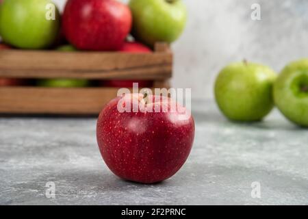Whole wet green and red apples on wooden cutting board Stock Photo