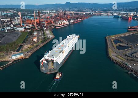 13 March 2021 - Port Kembla, NSW, Australia. Vehicles carrier HOEGH SHANGHAI enteris Port Kembla escorted by two tugboats. Stock Photo
