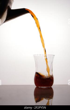 Tea pouring from blackened teapot to turkish tea glass Stock Photo