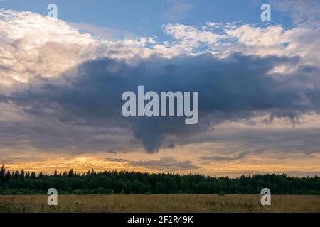 Before the rain. Thundercloud over an agricultural field on a summer evening Stock Photo