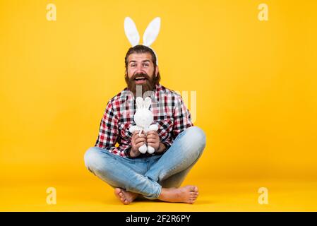 bunny brutal bearded man wear checkered shirt on easter having lush beard and moustache, happy easter Stock Photo