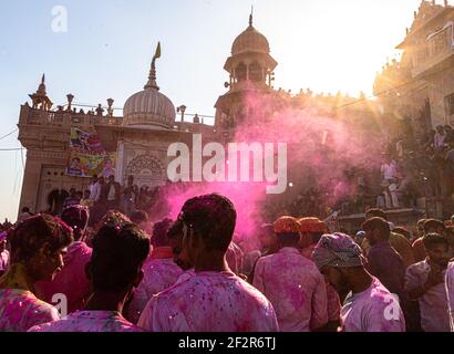 people celebrating holi at barsana on holi festival with selective focus on subject and added noise and grains. Stock Photo
