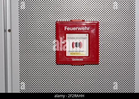 DUESSELDORF, NRW, GERMANY - JUNE 18, 2019: Fire alarm is installed in a red box on a white wall to ensure the safety and emergency system of fire prot Stock Photo