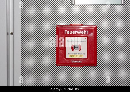 DUESSELDORF, NRW, GERMANY - JUNE 18, 2019: Fire alarm is installed in a red box on a white wall to ensure the safety and emergency system of fire prot Stock Photo