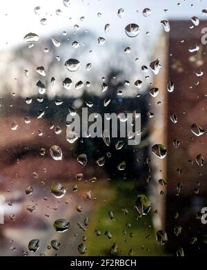 Raindrops on a window pane at home on a wet rainy day in UK Stock Photo