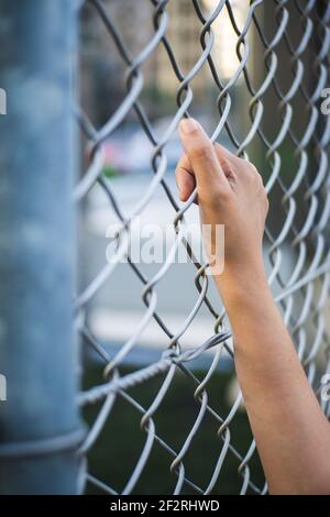 Picture of a hand leaning on the fence. Stock Photo