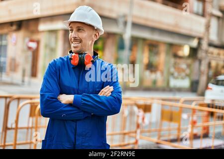 Young caucasian worker smiling happy wearing uniform at the city. Stock Photo