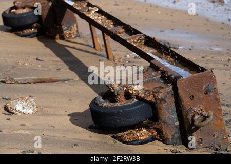 Wartime debris washed up on a beach due to coastal erosion Stock Photo