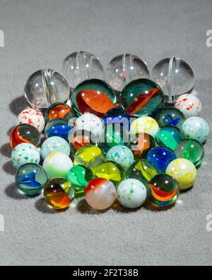 collection of various types and sizes of marbles grouped together Stock Photo