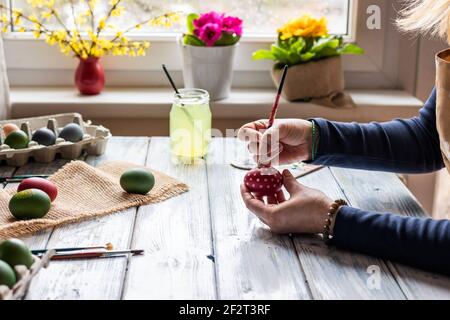 Painting Easter eggs. Woman making decoration for easter holiday. Art and creativity concept Stock Photo