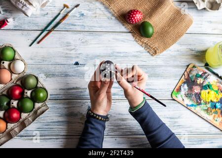 Painting Easter eggs. Woman making decoration for easter holiday. Table top view Stock Photo