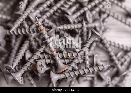 Oxidised screws, chrome-plated screws, brass-plated screws, a pile of assortment for domestic work. Stock Photo