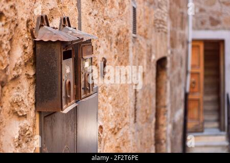 Metallic vintage mailbox on a brick wall. Orte, Italy Stock Photo