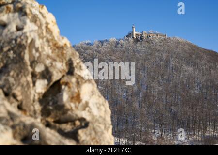 Castle also Stronghold (Teck) in winter on a clear evening with blue sky, many trees on the hill, huge rock in the foreground. Germany, Owen, Swabian Stock Photo