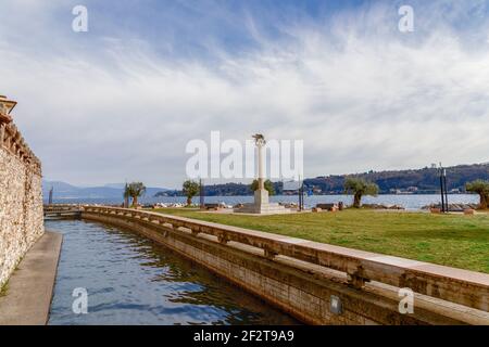 SALO, ITALY - FEBRUARY 24, 2019: Beautiful view of the canal and Lake Garda in the city of Salo (Salò). In the center of composition is the symbol of Stock Photo