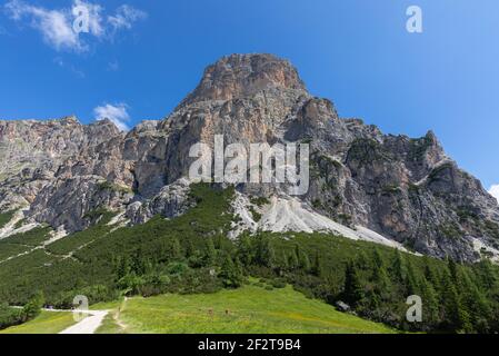 Sassongher mountain view from the foot with hiking paths and hikers. Italian Dolomites. Italian Alps, Colfosco - Alta Badia. Stock Photo