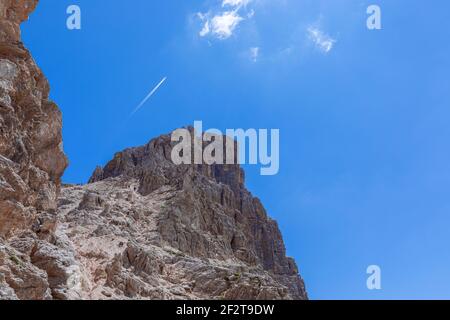 Climbers and hikkers climb to the top of the Sassongher mountain against the blue sky. Italian Dolomites, Colfosco - Alta Badia. Stock Photo