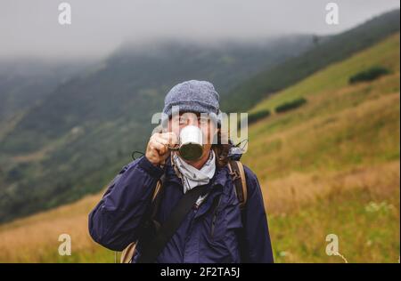 https://l450v.alamy.com/450v/2f2ta5j/hiker-drinking-hot-drink-from-cup-in-mountains-refreshment-during-hiking-in-cold-weather-2f2ta5j.jpg