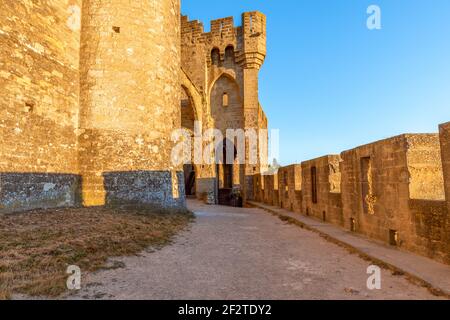 Wide fortified walls with walkways and arches of medieval castle of Carcassonne town at sunset Stock Photo