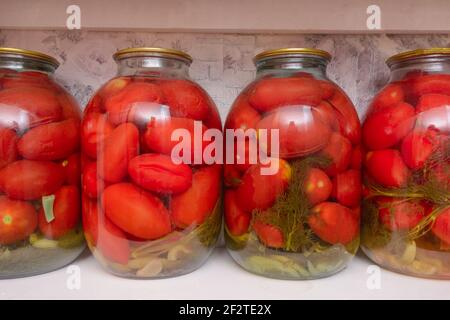 Jars of pickled red tomatoes. Harvesting vegetables for winter. Stock Photo