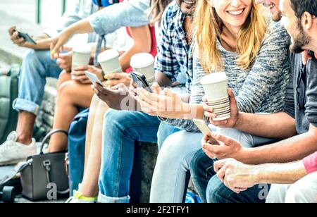 Millenial friends group using smartphone with coffee at university college - People hands addicted by mobile smart phone - Technology concept Stock Photo