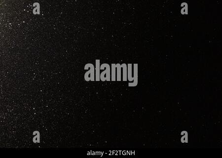Black texture with micro-relief and glitter similar to the night sky with stars Stock Photo