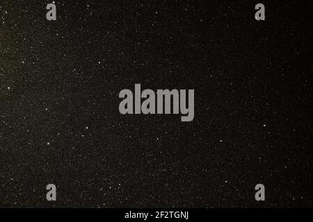 Black texture with micro-relief and glitter similar to the night sky with stars Stock Photo