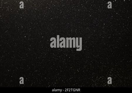 Black texture with micro-relief and glitter similar to the night sky with stars Stock Photo