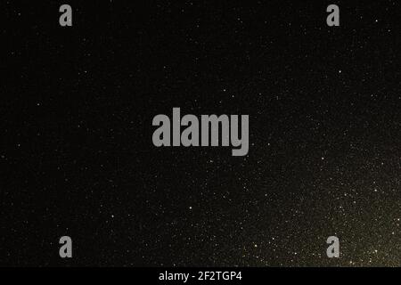 Black texture with micro-relief and glitter. Black glitter texture illuminated from bottom right to top Stock Photo
