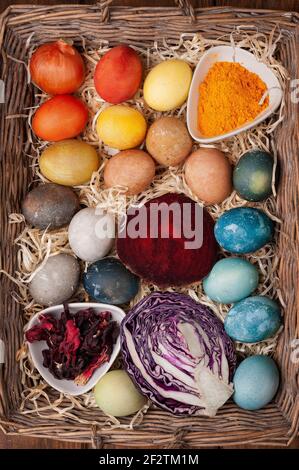 Natural dye for easter eggs - red cabbage, beetroot, carcade, turmeric and onion skin in a basket Stock Photo