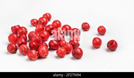 Red or Pink peppercorn scattered on board, closeup photo isolated with white background Stock Photo