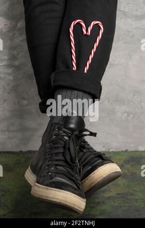 A woman inserted two heart-shaped candy canes into the cuffs of her pants Stock Photo