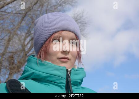 Portrait of teenage girl in early spring against blue sky. Stock Photo