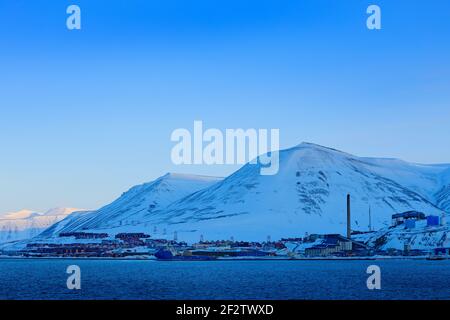 Longyearbyen, holiday travel in Arctic, Svalbard, Norway. People on the boat. Winter mountain with snow, blue glacier ice with sea in the foreground. Stock Photo