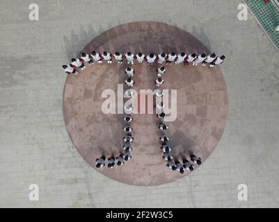 (210313) -- BAODING, March 13, 2021 (Xinhua) -- Aerial photo taken on March 13, 2021 shows students of the Zu Chongzhi High School standing in a formation of the Greek letter 'Pi' during an event commemorating Zu Chongzhi ahead of Pi Day in Laishui County, north China's Hebei Province. March 14 is celebrated around the world as Pi Day, since 3, 1, and 4 are the first three significant digits of the mathematical constant which denotes the ratio of a circle's circumference to its diameter. Zu Chongzhi, a Chinese mathematician and astronomer from the 5th century, had made a remarkable achieveme Stock Photo