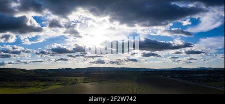 Sunlight passes through low clouds and illuminates a vineyard in Livermore, California. Some of the world's best vineyards exist in this region. Stock Photo