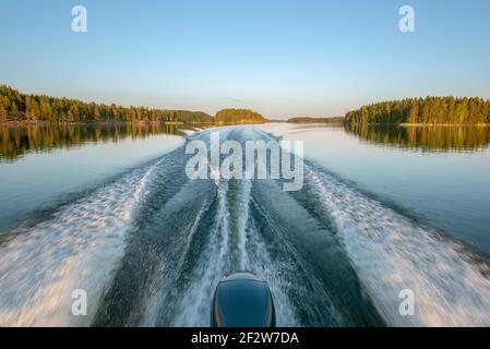 Trail on water surface behind of fast moving motor boat Stock Photo - Alamy