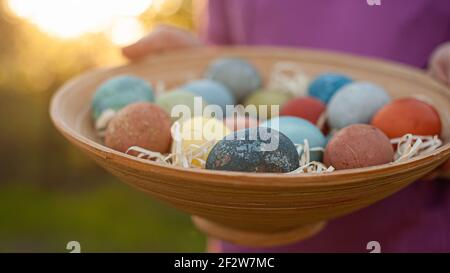 Girl holding a wooden plate with easter eggs Stock Photo