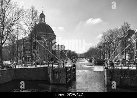 Amsterdam, Netherlands, February 12, 2021: Black and white picture of the dome church along the Singel canal in the old center of Amsterdam Stock Photo