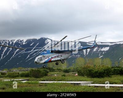 A helicopter is landing in the Valley of Geysers in Kamchatka, Russia Stock Photo