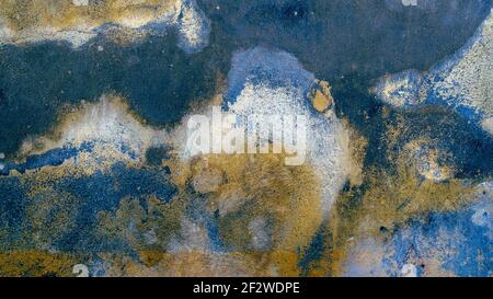 An old textured wall with different shades of blue and yellow. Stock Photo