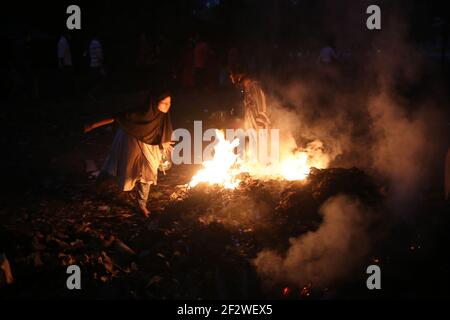 Dhaka, Bangladesh. 13th Mar, 2021. Dried leaves are being burnt to clear the park at the Suhrawardi Uddan as Amar Ekushey Book Fair 2021 is going to start in a few days.This year the book fair is starting late due to the novel coronavirus.Burning of leaves leads to air pollution, health problems and fire hazards. Credit: Md. Rakibul Hasan/ZUMA Wire/Alamy Live News Stock Photo